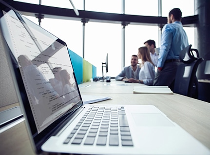 Office workers gathered around computer screen